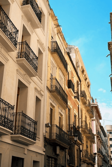 Spanish urban street with white facade and wrought-iron balconies