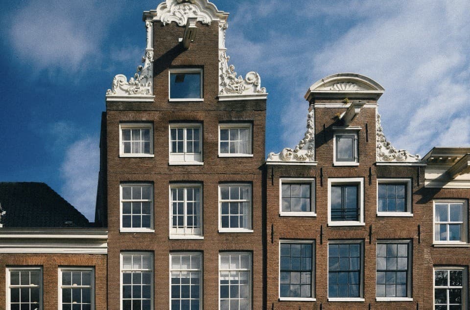 Traditional Dutch canal houses with ornate gables and hoist beams