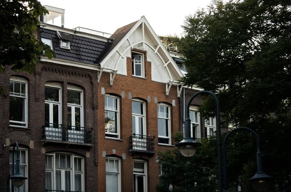 Dutch brick townhouses with white trim and wrought-iron balconies